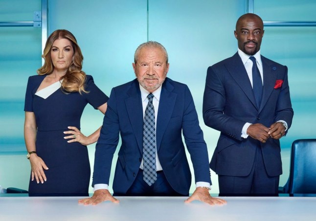 The Apprentice stars Lord Alan Sugar leaning on a table flanked by Baroness Karren Brady and Tim Campbell
